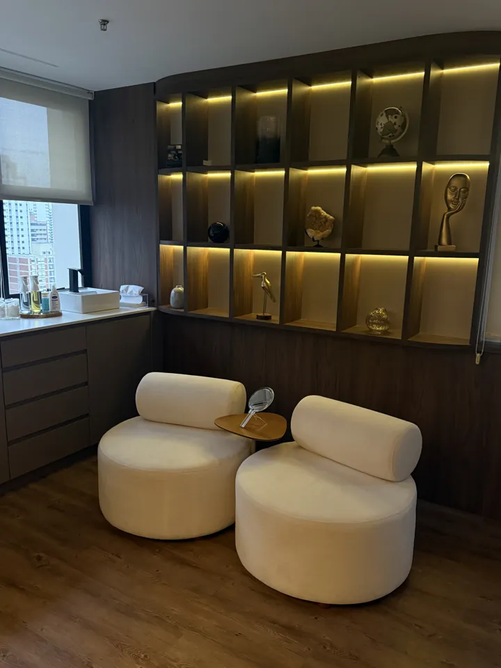 Sala da Pranay Clinic com poltronas e estante iluminada